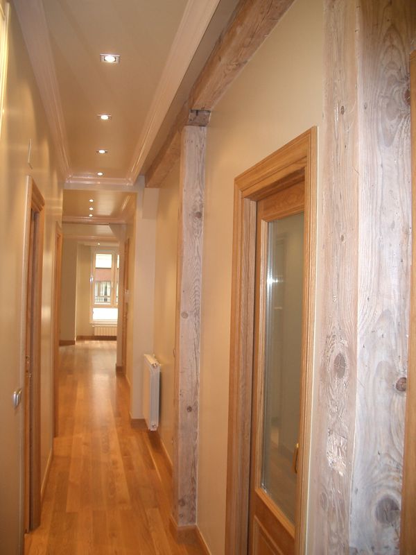 Pasillo amplio con suelo de madera y puertas de paso